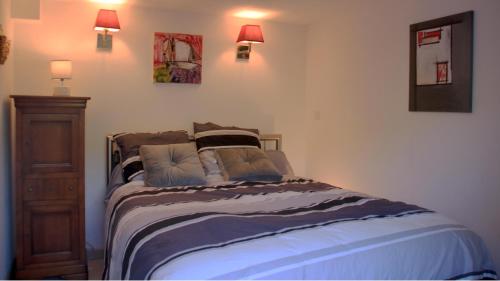 sypialnia z łóżkiem z poduszkami w obiekcie T2 climatisé baignoire terrasse Jacuzzi Piscine Sauna w mieście Launaguet