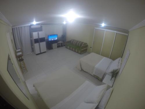 una vista aérea de una sala de estar con cama y TV en Flat Arraial, en Arraial do Cabo