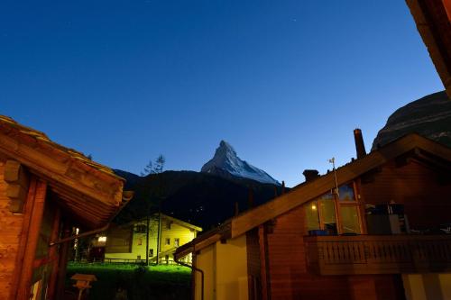 a mountain in the background of a town with buildings at Casa Della Vita by Zermatt Premium Apartments in Zermatt