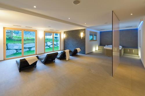 a room with a bed and a room with chairs at Casa Della Vita by Zermatt Premium Apartments in Zermatt