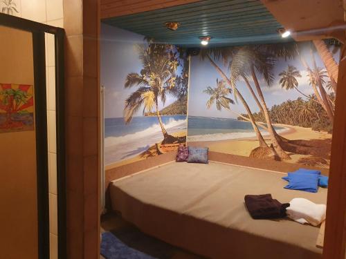 a bed in a room with a mural of a beach at Ferienhaus Waidmanns-Heil in Höchenschwand