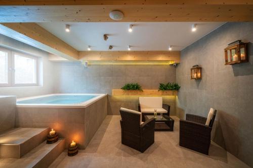 y baño con bañera, mesa y sillas. en Willa Litworówka III Wellness&SPA en Poronin