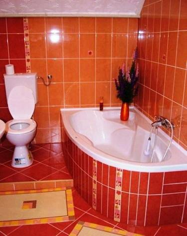 a bathroom with a toilet and a tub with a sink at Unicum Vendégház in Abádszalók
