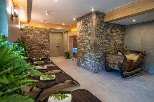 a lobby with a row of chairs and a stone wall at Willa Litworówka III Wellness&SPA in Poronin
