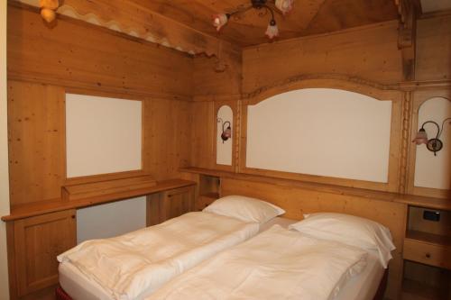 a bedroom with two windows and a bed in it at Maso Margherita in Commezzadura