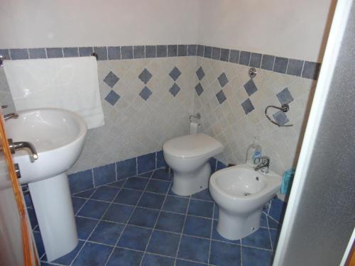a blue tiled bathroom with a sink and a toilet at Casa Vacanze Caccamo Santa Lucia in Caccamo