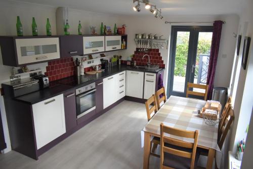 uma cozinha com uma mesa e uma sala de jantar em Hawthorn Cottage em Glencoe