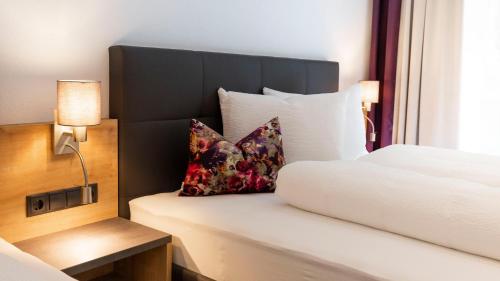 a hotel room with a bed and two pillows at Aparthotel Lerch in Kappl