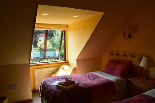 um pequeno quarto com 2 camas e uma janela em Sunflower Bed & Breakfast em Findhorn