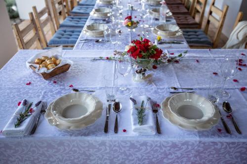 a long table with white plates and flowers on it at Provence Birtok in Decs