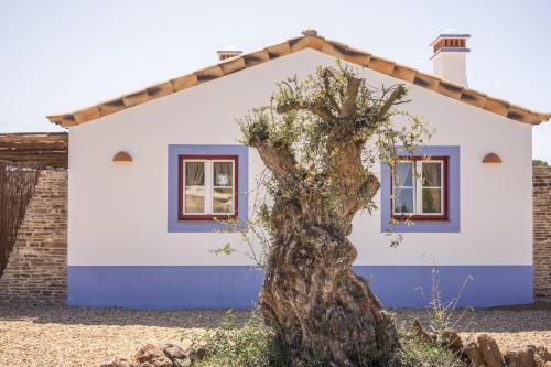 a small house with a tree in front of it at Monte da Boavista in São Teotónio