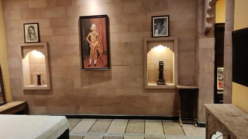 a room with three framed pictures on a wall at Jodhpur Palace Guest House in Jodhpur