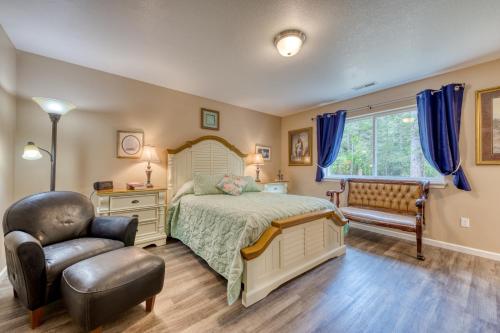 a bedroom with a bed and a chair and a window at The Captain's Quarters in Rockaway Beach