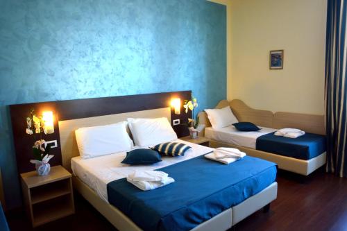 um quarto de hotel com duas camas com paredes azuis em B&B Marbò Florence em Florença