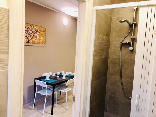 y baño con mesa y ducha. en U Peri Alivu House, en Catania