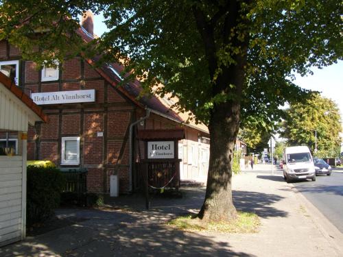 a building on the side of a street with a tree at Hotel Alt Vinnhorst in Hannover