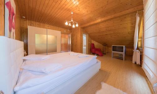 ブシュテニにあるVilla Moonのベッドルーム(白い大型ベッド1台、赤い椅子付)