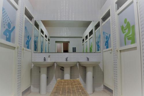 ein Badezimmer mit 3 Waschbecken und einem großen Spiegel in der Unterkunft L'AUBERGE DE TENNIS MSC in Marrakesch