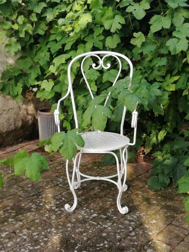 a white chair sitting in front of a plant at Tankefuld Living's Horsefarm in Svendborg