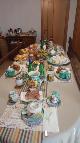 a long table with plates of food on it at Domus Elisa in San Cipriano Picentino