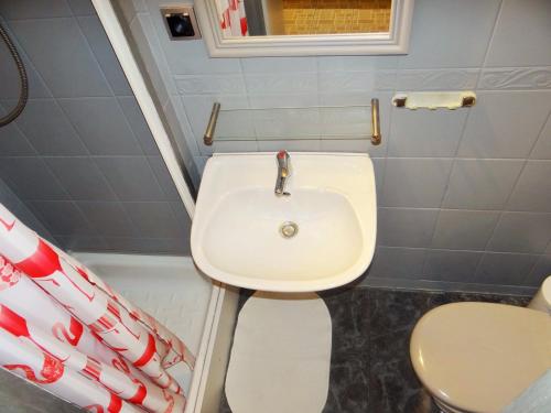 a bathroom with a white sink and a toilet at Familijny Apartament z Garażem in Legnica