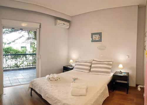 una camera da letto con un letto e due asciugamani di A2 Cute Vouliagmeni Apt in a Unique Spot ad Atene