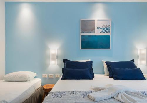 two beds in a room with blue walls at Pousada Olho D'água in Maragogi