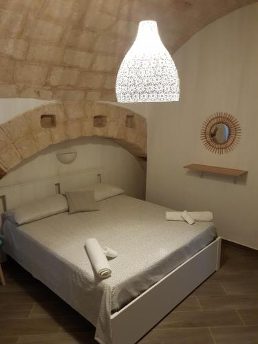a bedroom with a large bed with a stone wall at Casa Arco della Chicca in Monopoli
