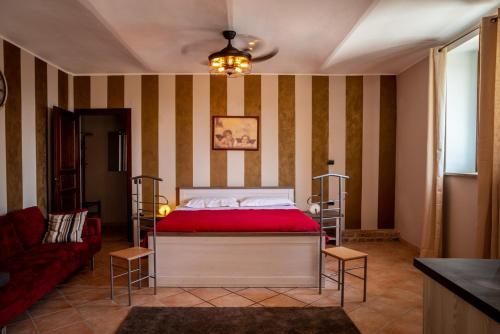 a bedroom with a red bed and a couch at CASA RAMAGIO' in La Morra