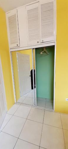 a room with a door and a room with yellow walls at Spring Palm Estate in St Mary