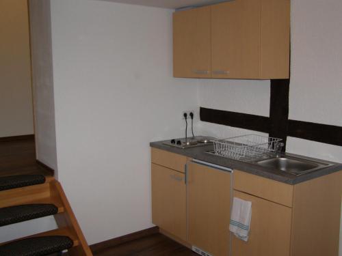 una pequeña cocina con fregadero y encimera en Hotel Alt Vinnhorst en Hannover