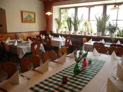 une salle à manger avec des tables, des chaises et des plantes dans l'établissement Zum Weißen Rössl, à Kallmünz