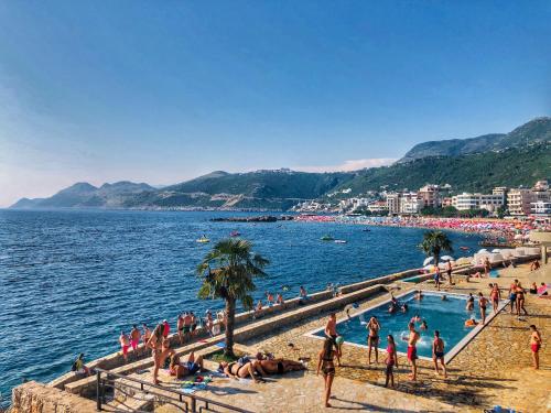 a group of people swimming in the water at a beach at Studios Seaview in Dobra Voda
