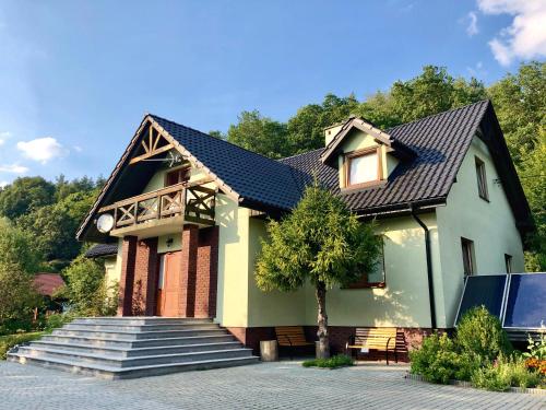 uma casa com um telhado preto e escadas em Sianki nad Sanem em Sanok