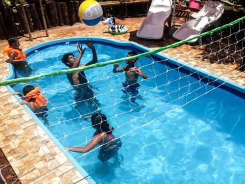 a group of children playing in a swimming pool at Vacaciones Aregua (Casa Pablo) in Areguá
