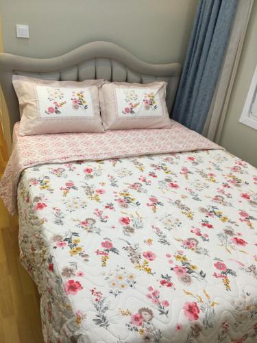 a bed with a floral bedspread and two pillows at PASHA APART~BOUTİQUE HOTEL/YALOVA in Yalova