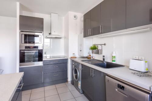 a kitchen with blue cabinets and a sink at *SPACIOUS APARTMENT DISNEYLAND PARIS* in Serris