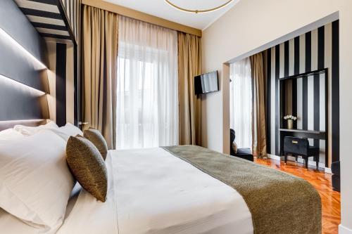 pokój hotelowy z dużym łóżkiem i telewizorem w obiekcie Frattina High-end apt w Rzymie