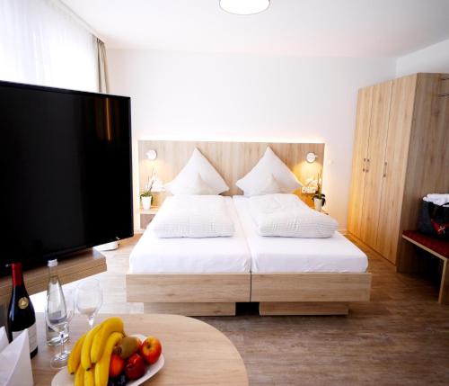 a bedroom with a bed and a table with a plate of fruit at Kohlers Hotel Engel in Bühl