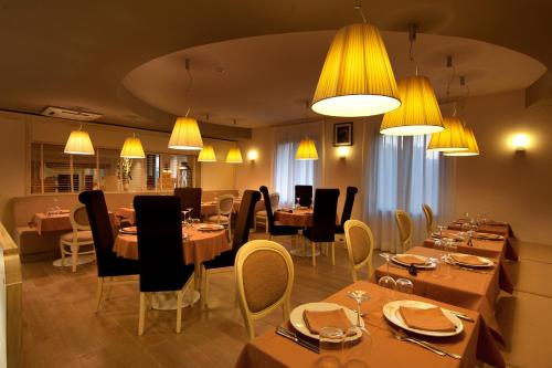 a restaurant with wooden tables and chairs and lights at Gran Paradiso Hotel Spa in San Giovanni Rotondo