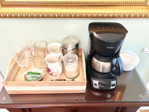 a coffee maker and cups on a table at Redwood Bed and Breakfast in Niagara Falls