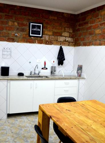 a kitchen with a sink and a wooden table at Visto Hostel in Sao Paulo