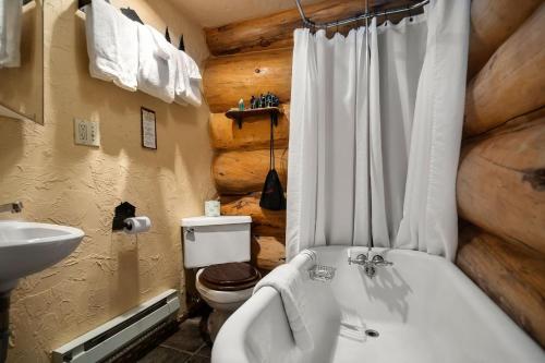a bathroom with a toilet and a tub and a sink at Bar N Ranch in West Yellowstone
