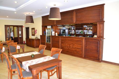 a restaurant with a table and chairs and a bar at Hotel Neo Międzyrzecz in Międzyrzecz