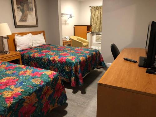 a hotel room with two beds and a desk at Park Motel in Tampa