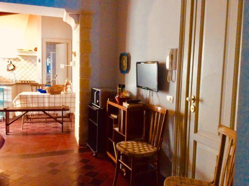 a living room with a tv and a chair at Casa del Nespolo sul Mare, Santa Maria la Scala in Acireale