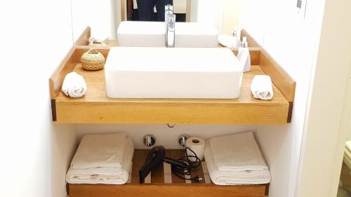 baño con lavabo y toallas en un estante en Studio Altos de Juramento en Salta