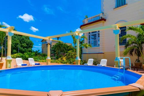 a swimming pool with chairs and a house at La Villa Teresa in Havana