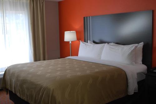 a hotel room with a large bed with white pillows at Quality Inn & Suites Fresno Northwest in Fresno