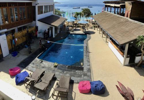 una vista aérea de una piscina con sillas y sombrillas en Dream Divers Resort en Gili Trawangan